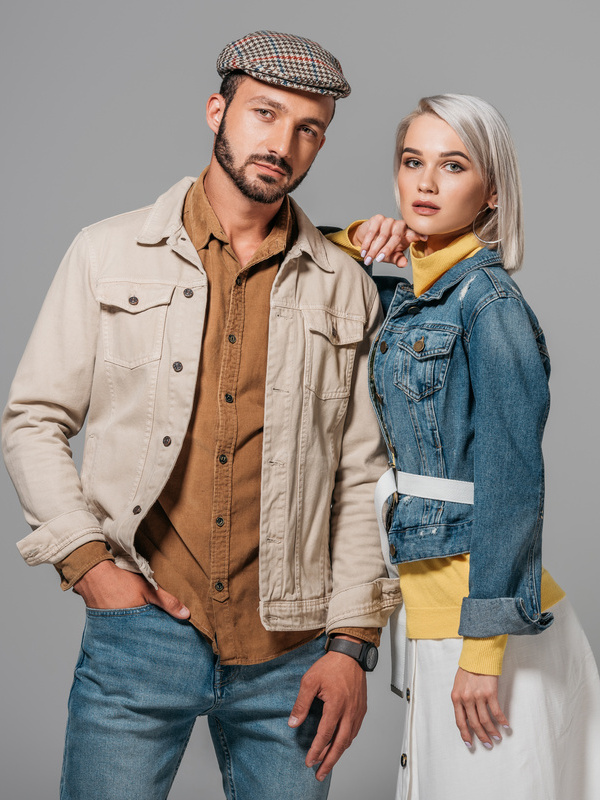 beautiful couple of models posing in autumn outfit, isolated on grey
